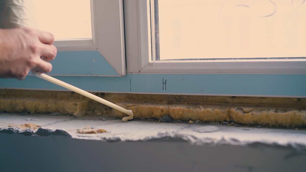 caulking around windows to reduce cold drafts and prevent heat loss